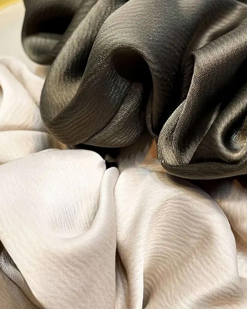 The image displays a Satin Hair Scrunchie, a luxurious and practical hair accessory. Its texture is soft to the touch, providing gentle support for hair without causing breakage or pulling.