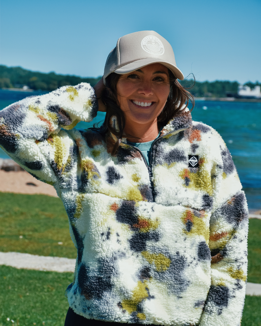 This image depicts the Lakes and Grapes Coastal Lifestyle Trucker Hat. The hat is a classic trucker style with a structured front panel and a gently curved brim. It's a versatile and fashionable accessory suitable for outdoor activities and coastal enthusiasts.