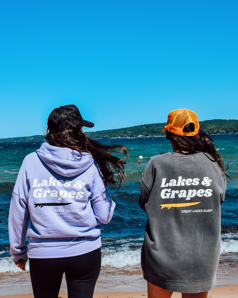 
            
                Load image into Gallery viewer, In this image, we see a Lakes and Grapes Great Lakes Surf Hoodie. This sweatshirt, available in a cool dark lavender color, captures the spirit of the water like no other.
            
        
