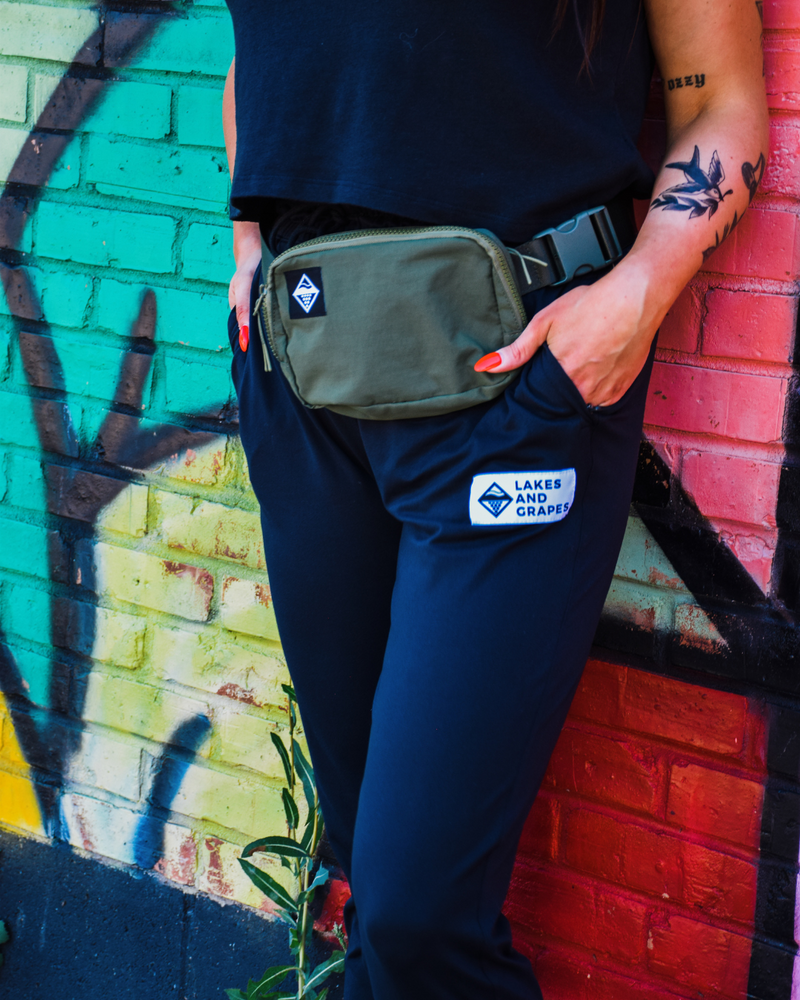
            
                Load image into Gallery viewer, This image showcases the Lakes and Grapes Classic Belt Bag in Forest Green. It&amp;#39;s crafted with both fashion and function in mind, providing a secure and accessible way to carry your essentials while on the go.
            
        