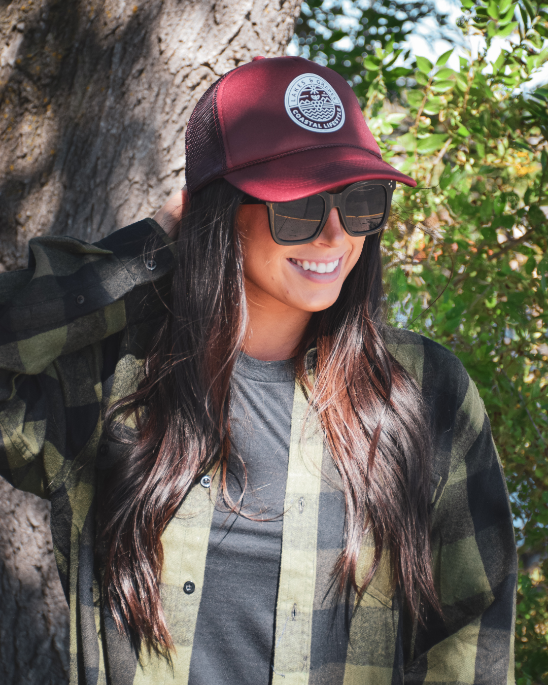This image depicts the Lakes and Grapes Coastal Lifestyle Trucker Hat. The hat is a classic trucker style with a structured front panel and a gently curved brim. It's a versatile and fashionable accessory suitable for outdoor activities and coastal enthusiasts.