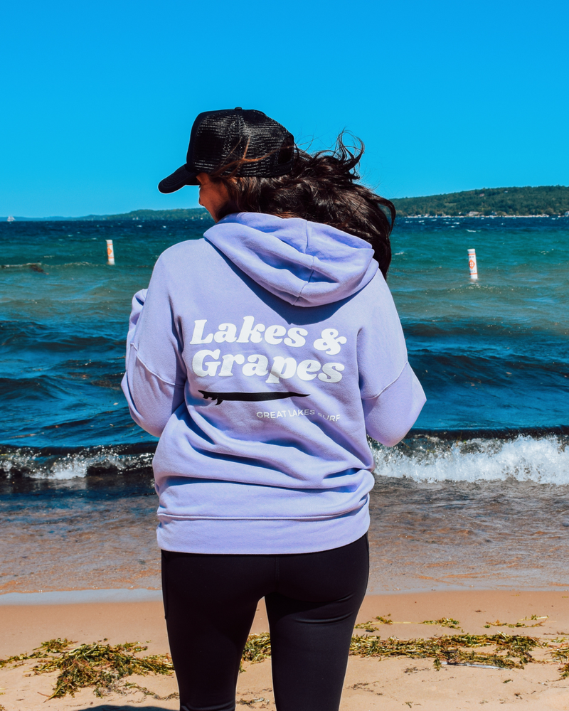 
            
                Load image into Gallery viewer, In this image, we see a Lakes and Grapes Great Lakes Surf Hoodie. This sweatshirt, available in a cool dark lavender color, captures the spirit of the water like no other.
            
        