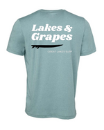 This image features a Lakes and Grapes Great Lakes Surf Tee. Crafted for those who can't get enough of the water, this tee captures that lake-life spirit effortlessly.