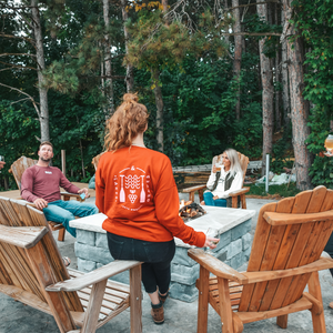 Rose by the Bay Crew Sweatshirt by the fireplace while wine tasting in Traverse City at Two K Farms