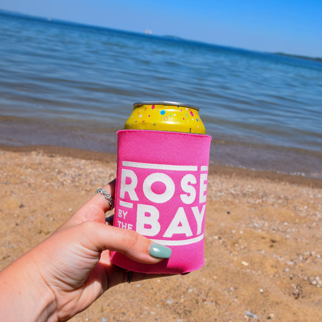Holding the Pink Rosé by the Bay Koozie on West Bay Beach along West Bay in Downtown Traverse City