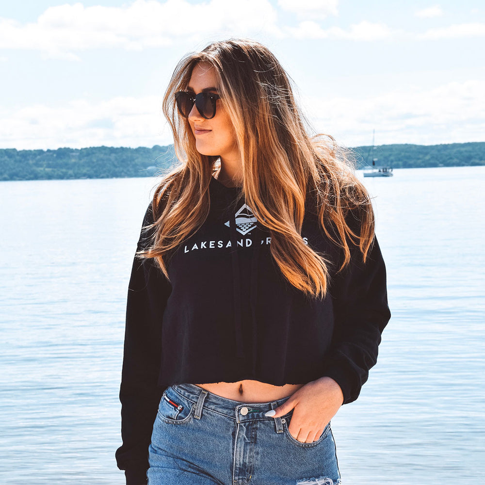 
            
                Load image into Gallery viewer, Lakes and Grapes black cropped hoodie with white lettering is your fun summer sweatshirt that is fit for all events- on the boat or around the campfire, the warm and stylish sweatshirt will be your summer favorite.
            
        
